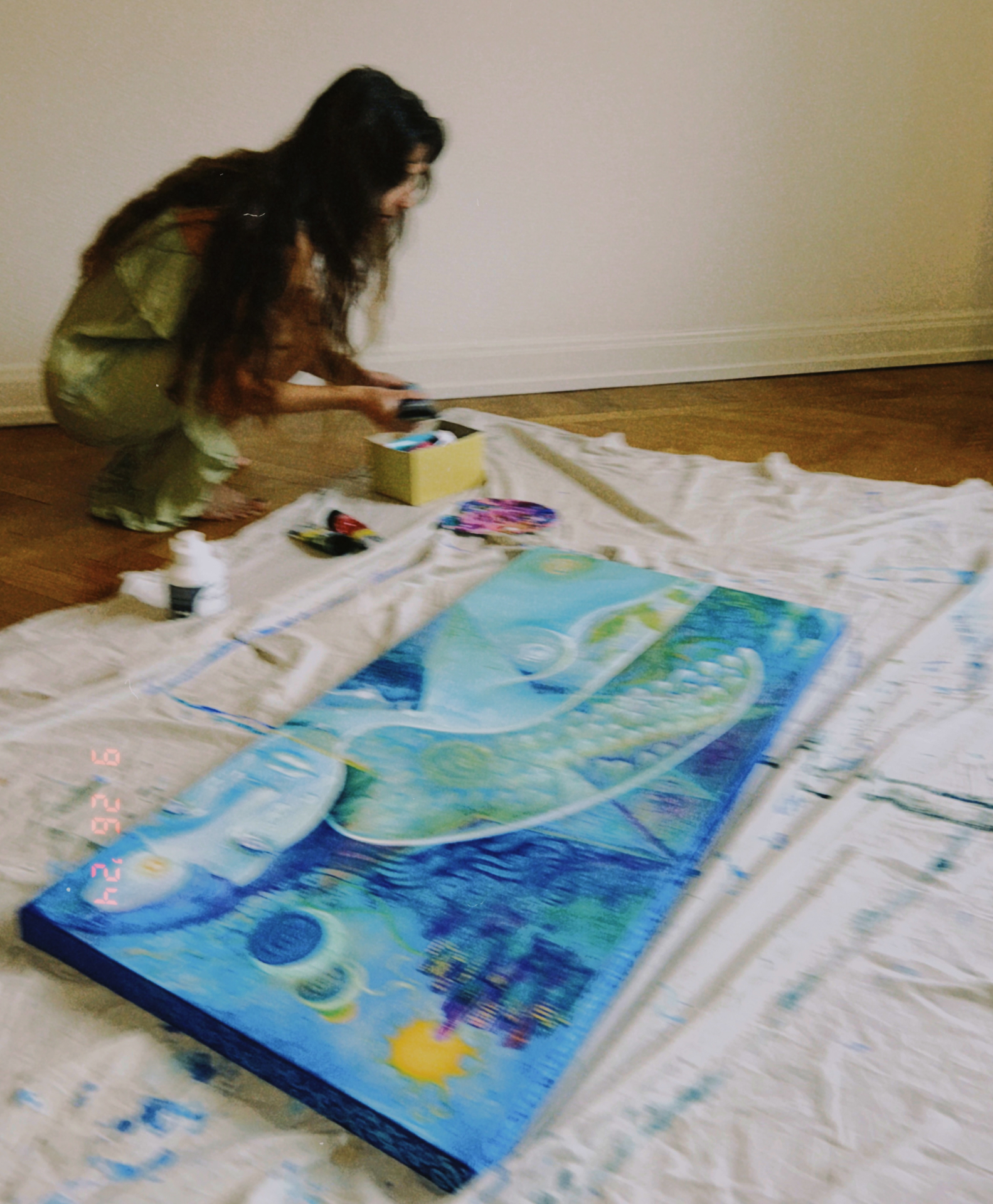 Norea working on a canvas on the floor